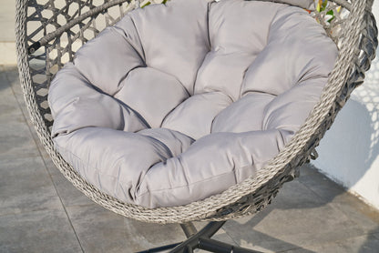Hängekorb Cookie mit hellgrauem Sitzkissen an einem grauen Outdoor-Aluminium‑Standfuß, auf Terrassenboden positioniert